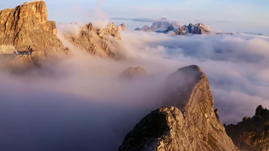 Clouds on top of mountain peaks at day time with mountain summits