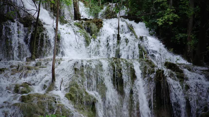 The waterfall race down in a series of cascades in the woods