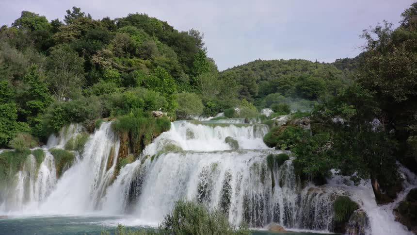View of a waterfall with hills and trees