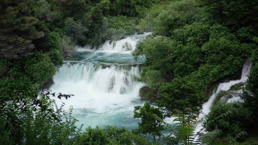 The waterfall race down in a series of cascades in the woods