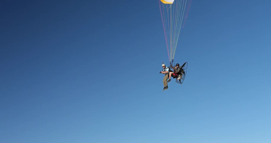 People are flying through the air parasailing