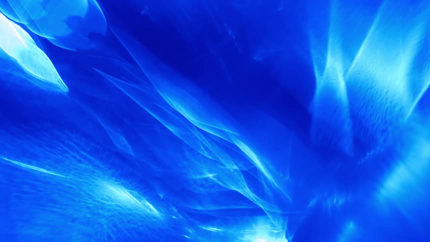 A white light glows behind a transparent blue shade to create shapes and patterns