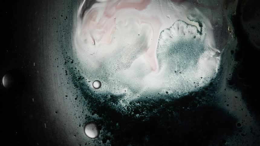 Pink silver and black textures moving around in a liquid