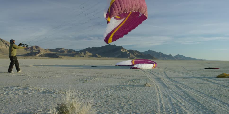A man pulls a sail up into the air