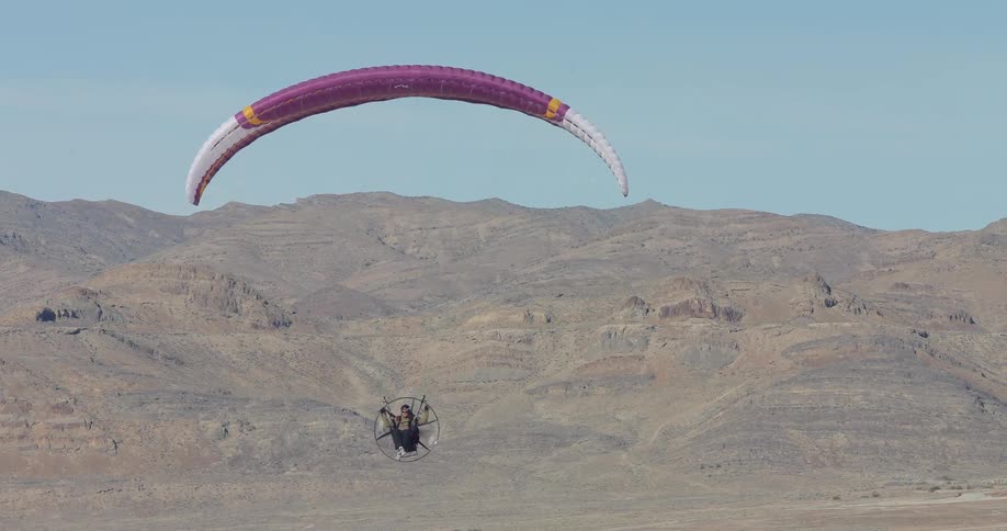 A person is paragliding through the sky