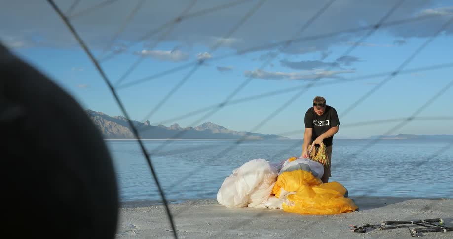 A man works to pick up a parachute