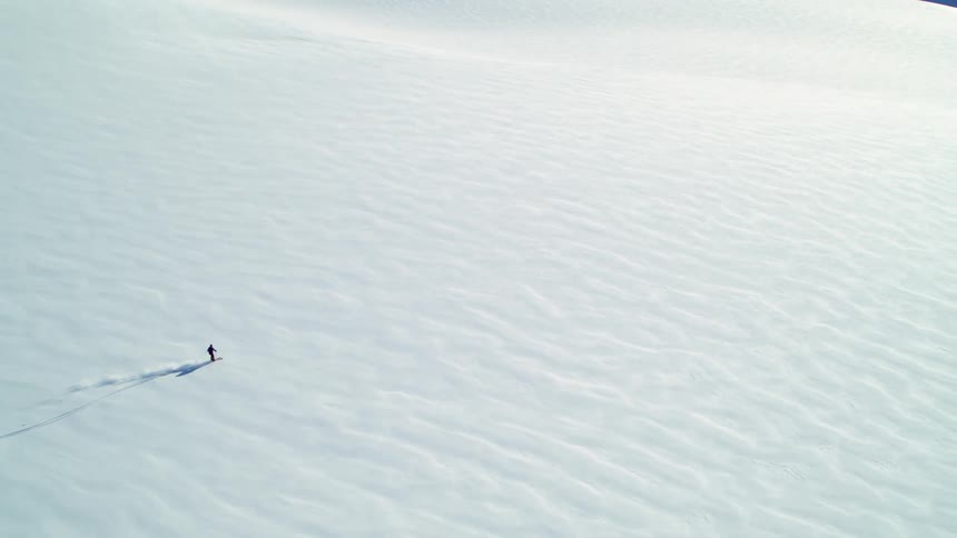 A person skis down a snowy slope