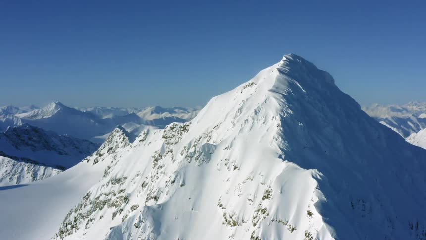Sun shines on snow capped mountains