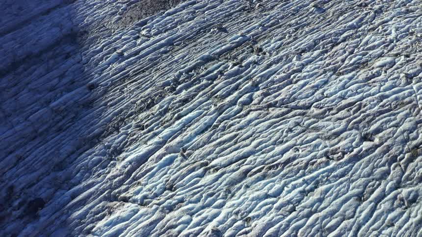 A layer of snow covers rocky terrain