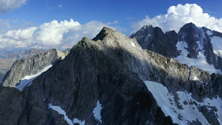 Mountain range with peaks high in the sky on a cloudy day