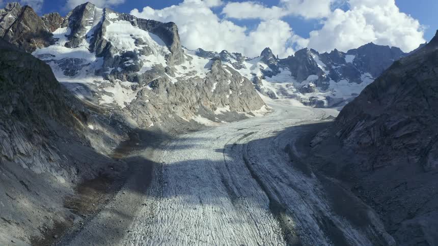 Mountain pass at day time next to mountain peaks covered in snow