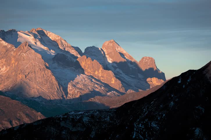 Shadows flow across snow speckled mountains as time passes
