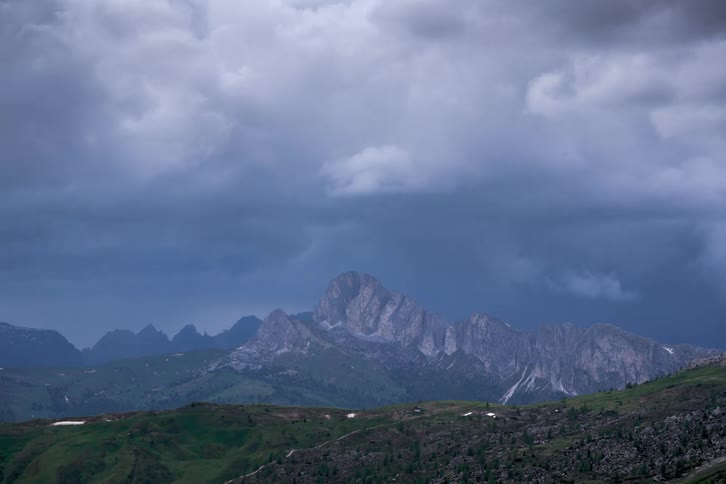 Clouds roll across the sky over a mountain range in the distance