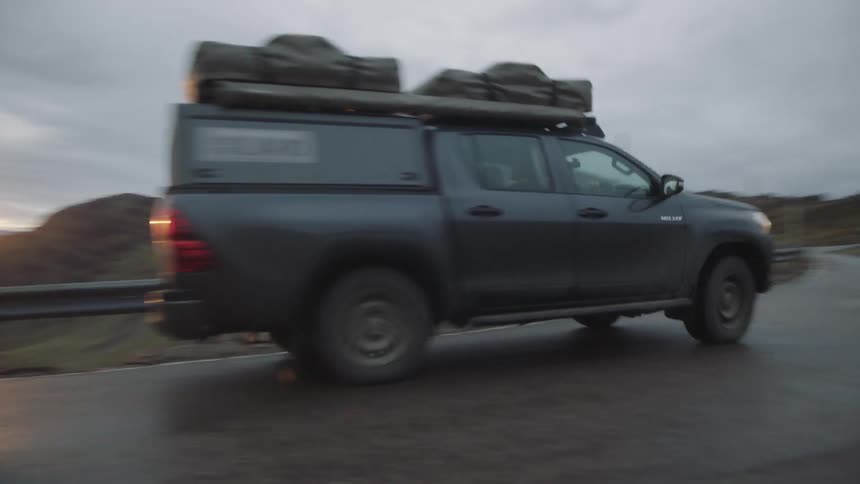 A sport utility vehicle speeds down a curved mountain road