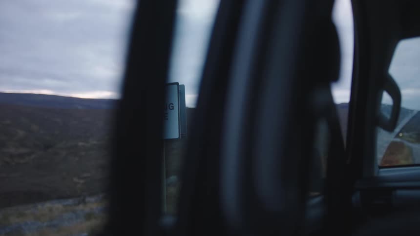 A car parked near a signpost opens the door and gets into her vehicle