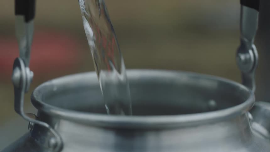 Water pouring into a metal tin