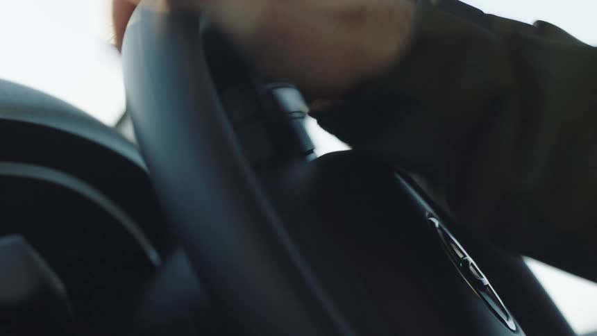 Person turns the steering wheel with a toyota logo