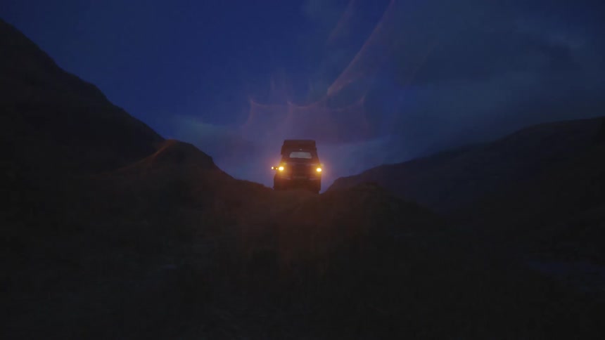 Vehicle park on top of a slope at night with its hazard lights on