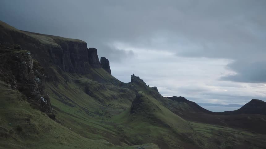 Overcast sky with hill or mountainside with jagged peaks