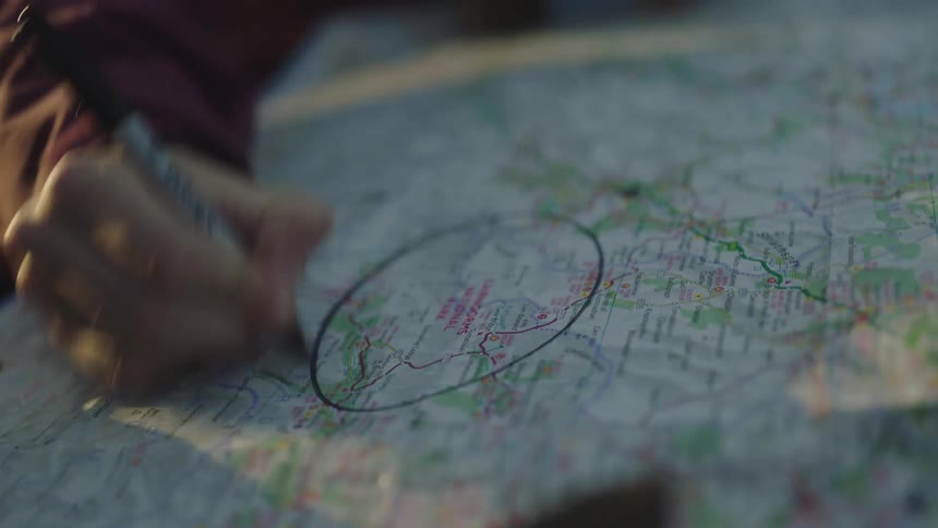 A person circles a location on a map