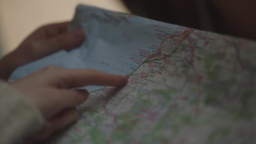 Hand moving across a map pointing at different locations