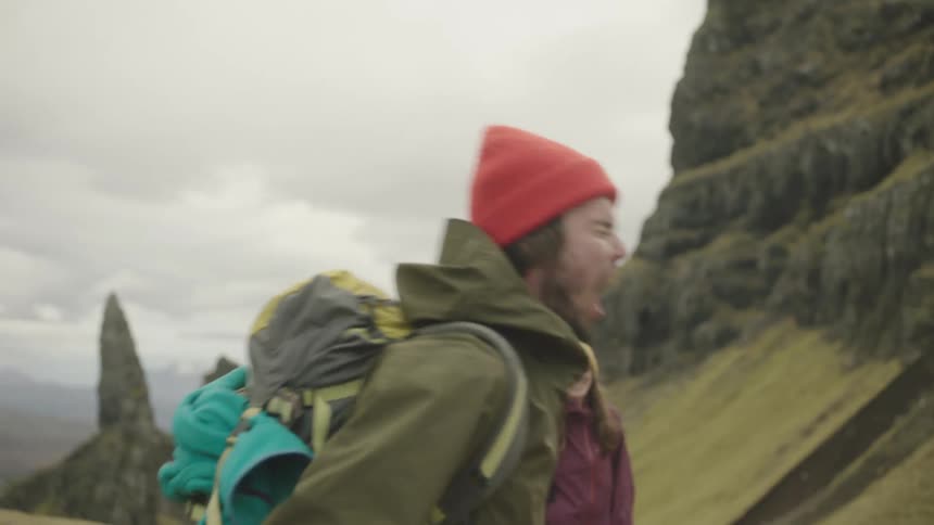 A man pretends to howl and then laughs along with his hiking companion