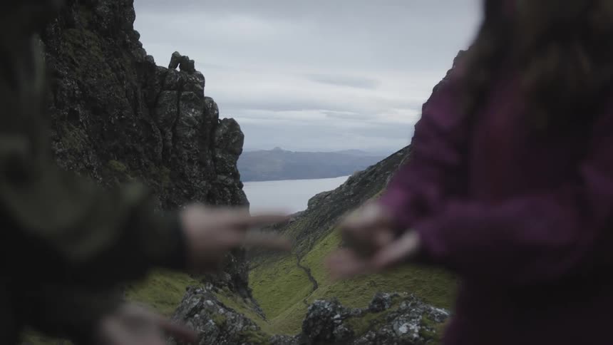 A father and daughter playing rock paper scissors on a mountain