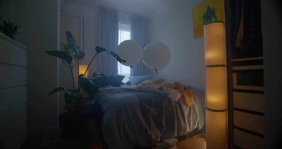A bedroom with a potted plant and lamps