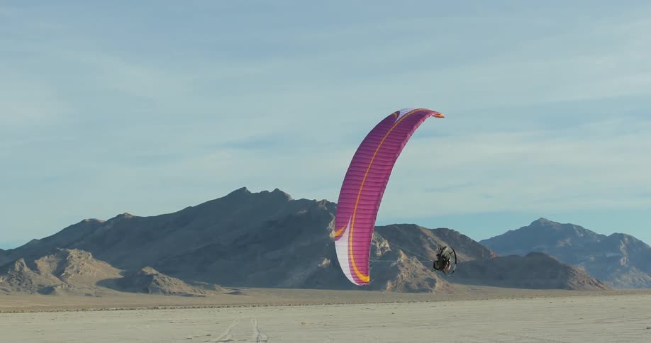 A person using a paramotor to fly in circles