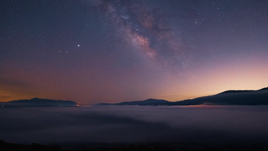 Time lapse of stars in the sky and clouds moving across the land