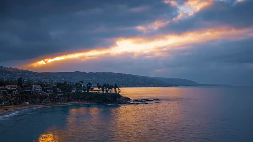 The sun sets and rises over a coastal neighborhood