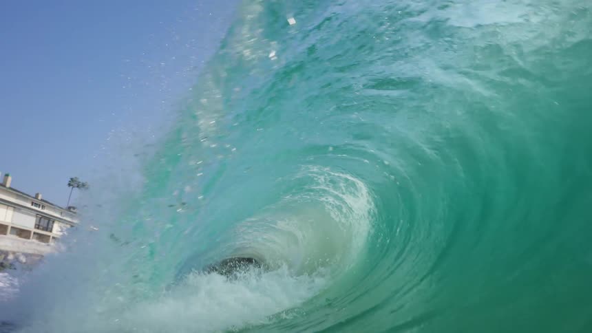 A wave crashing in front of a shoreline