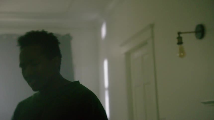 A young man spins around his living room