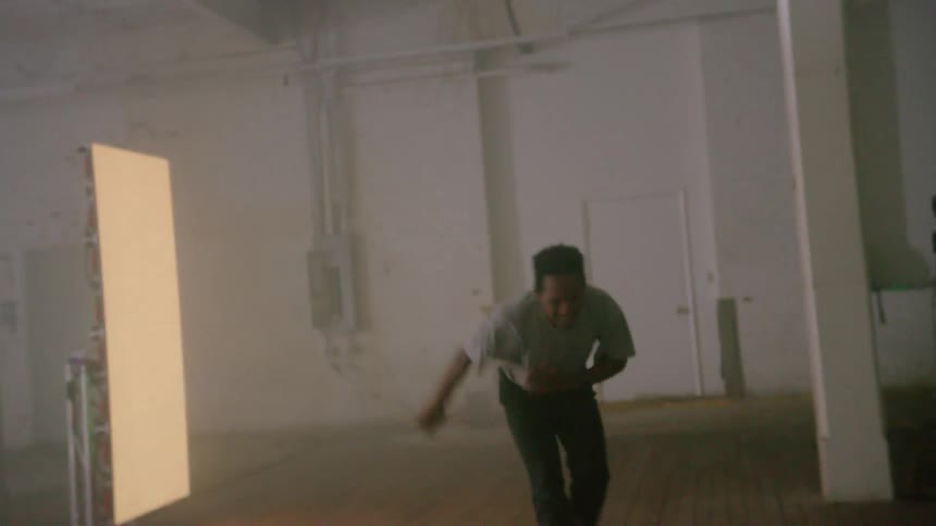 A man dancing in a studio near a screen