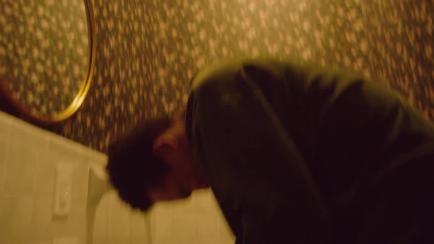 A man slams his hands in frustration as he stands at the sink in a half bath