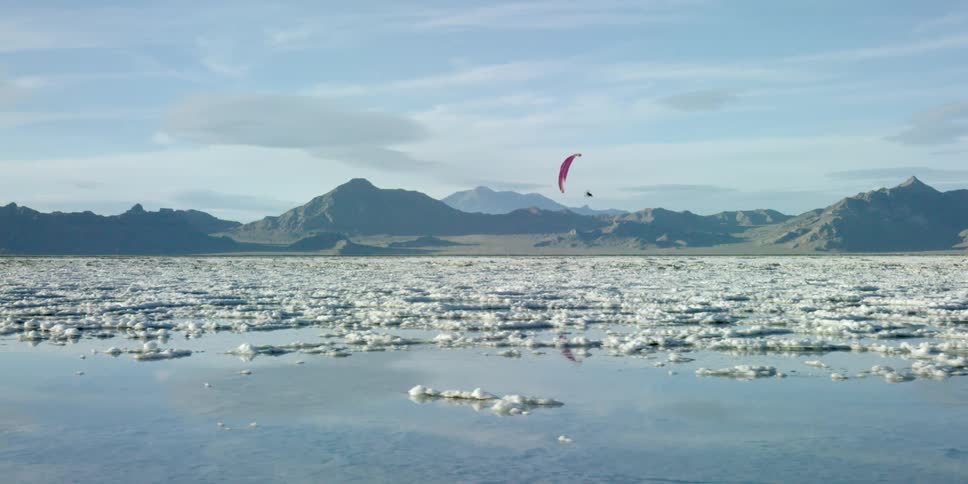 Person with parasail floating over a salt lake