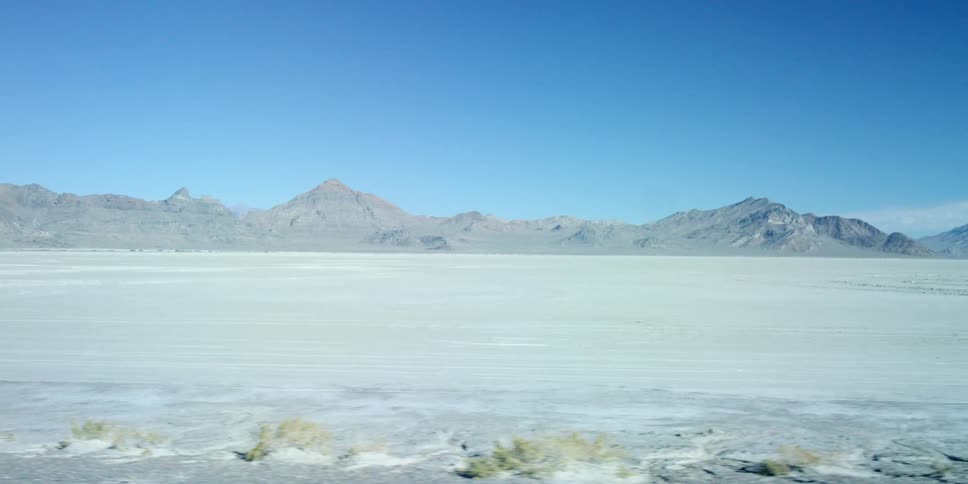 Rolling view of an open deserted plain with mountains in the background