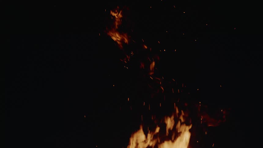 High flames release sparks into air at night