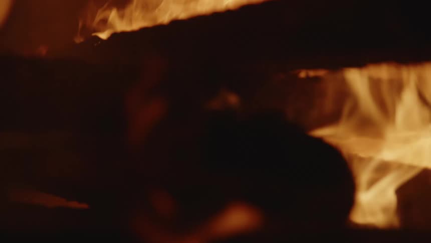 Flames burning on a large structure with stacked wood