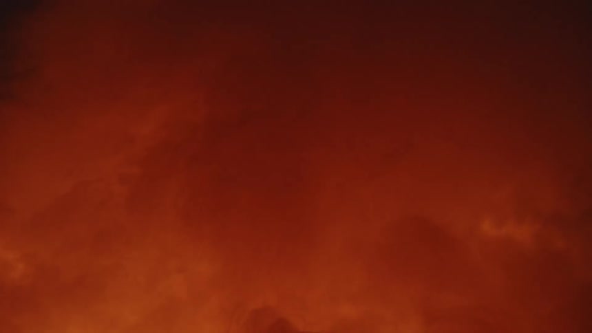 Clouds of thick smoke billow up from a brightly burning fire