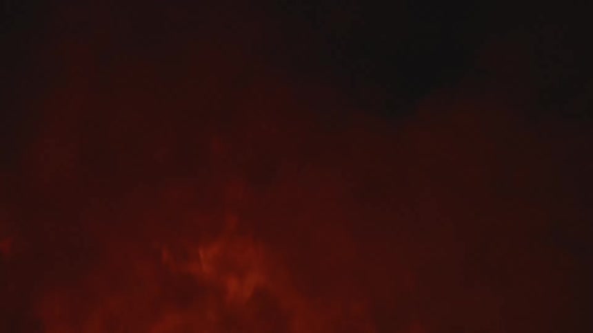 Fire burning outside at night on vegetation