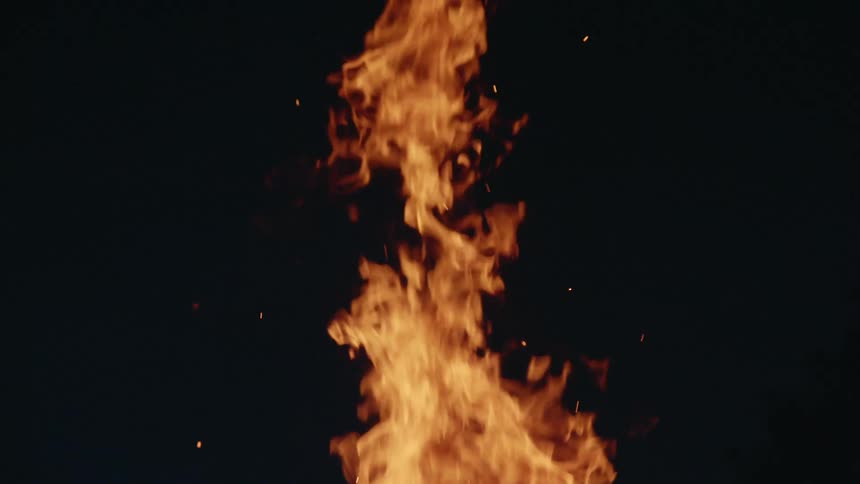 Fire flames and embers rising into the darkness