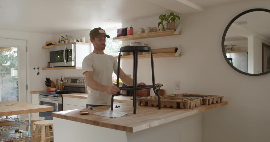 A man assembles a stool at home