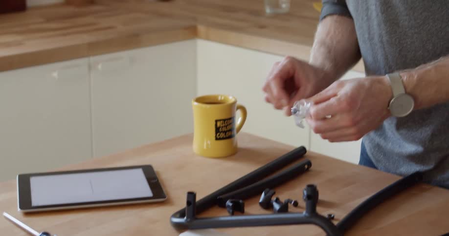 Man standing in his kitchen at home assembling a piece of furniture
