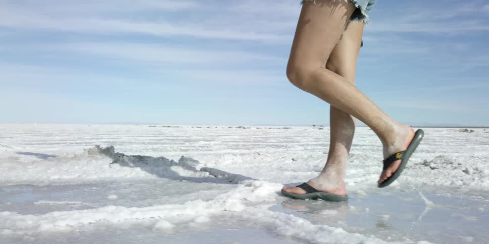 A person is walking over a field covered with ice and snow