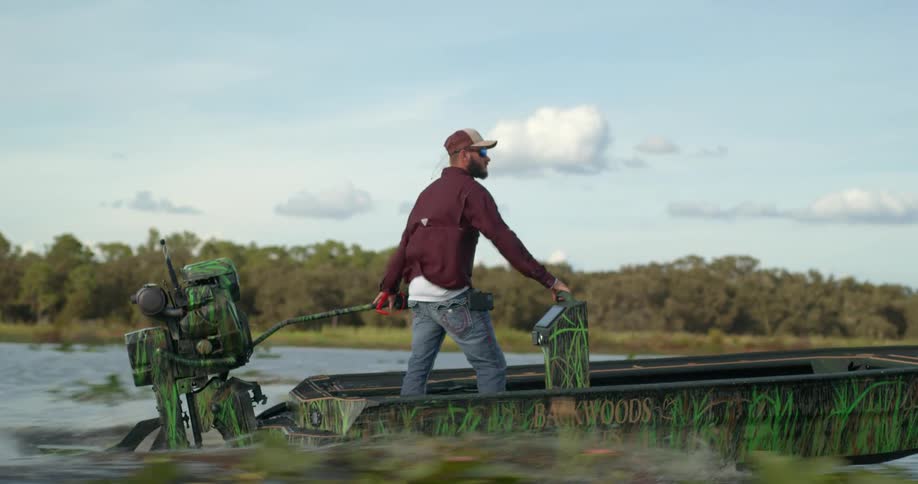 Man standing in a small moving boat at daytime on a river