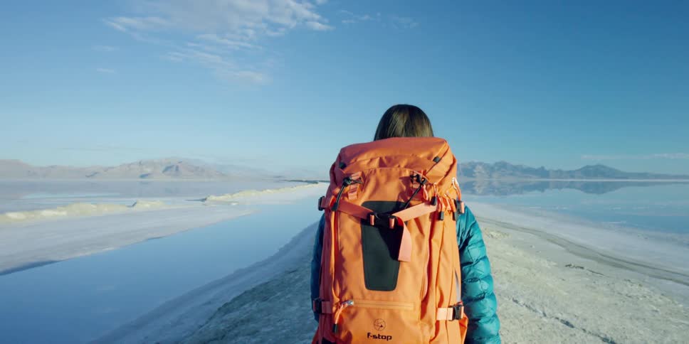 Woman hiking on a small hill surrounded by a salt lake