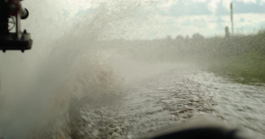 Water splashes everywhere as an air boat rides through a swamp
