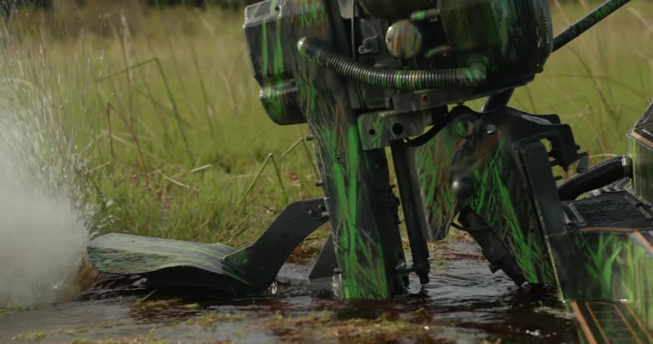 An airboat kicks up water as it moves through a swamp