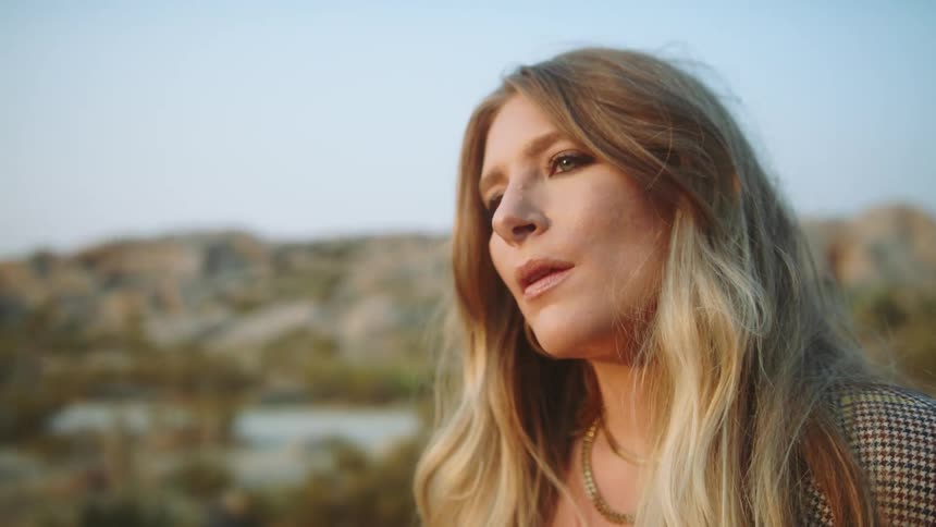 A woman standing outside looks in to the distance